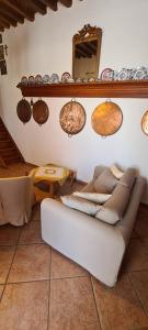 a couch in a living room with plates on the wall at Traditional House in Skiros