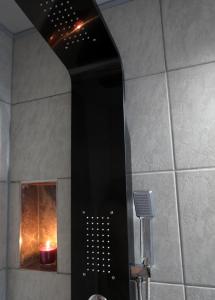 - czarny prysznic ze świecą w łazience w obiekcie művészház apARTman w Balatonfüred +8 zdjęć