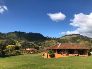 a house in a field with a mountain in the background at Pousada das Flores in Gonçalves +31 photos