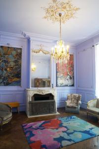 a living room with a fireplace and a chandelier at AZAL1889 in Calais