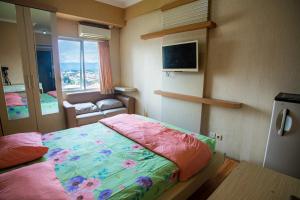 マランにあるApartemen Soekarno Hatta by Easy Staycation 3のベッドと椅子と窓のある寝室