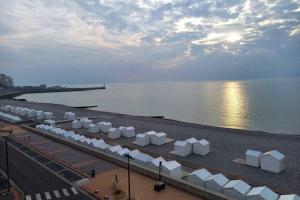 una playa con sombrillas blancas y agua en Villa Mignon grand studio vue Mer, en Mers-les-Bains