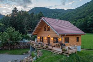 a large wooden house with a porch and mountains at Chalet Rothenbach in Mittlach