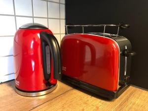 two red toasters sitting next to each other on a counter at Villa Lou in Mössingen