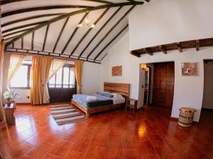 1 dormitorio con 1 cama y suelo de madera en Nibiru Hostel en Villa de Leyva