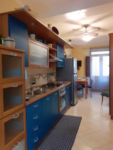 a kitchen with blue cabinets and a stainless steel refrigerator at La casa di Ladì in Scilla