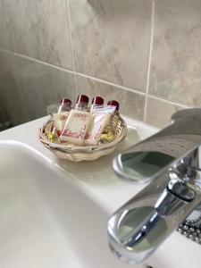 una cesta de cepillos de dientes en el lavabo del baño en Hostal Pitiusa, en Ibiza