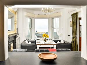 Una sala de estar con mesa y sillas y un comedor. en Wavecrest, en Pwllheli