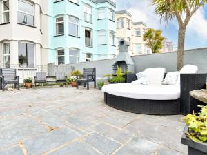 a patio with a couch and chairs in front of a building at Wavecrest in Pwllheli