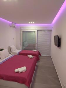 2 bedden in een kamer met paarse verlichting bij Villa la vie in Ulcinj