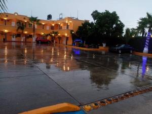 a parking lot with cars parked in the rain at HOTEL PARAÍSO DEL VALLE in Ciudad Constitución