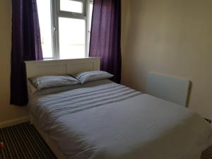 a bed in a room with a window at Camber Sands Holiday Chalets - The Grey in Camber