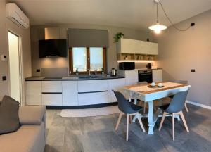 a kitchen with a table and chairs in a room at La Roggia - Historic Molino Maufet Watermill - Lake Como in Colico