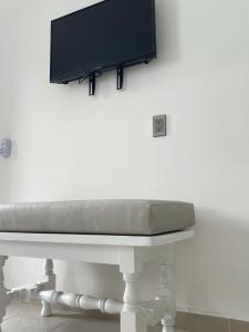 una mesa blanca con TV en la pared en AZUL ARENA Hotel Boutique, en Mazatlán