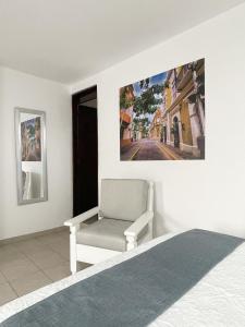 a bedroom with a bed and a chair next to a window at AZUL ARENA Hotel Boutique in Mazatlán