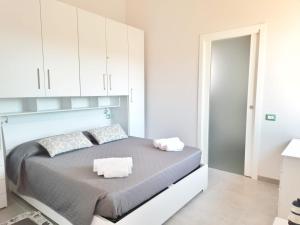 una camera bianca con un grande letto con armadi bianchi di Monolocale Arbus R0478 ad Arbus