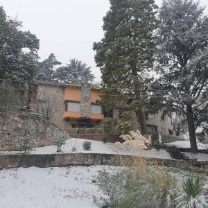 una casa con nieve en el suelo delante de ella en Las Terrazas Resort & Apart-Cabañas en La Falda