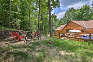 einen Hinterhof mit Stühlen, einem Tisch und einer Blockhütte in der Unterkunft Butler Cabin on 19 Acres with Hot Tub and Fire Pit! in Butler