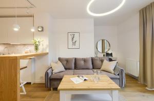 uma sala de estar com um sofá e uma mesa em Apartament Green Park, Polanica Residence garaż podziemny w cenie & mini SPA & Rowery em Polanica-Zdrój