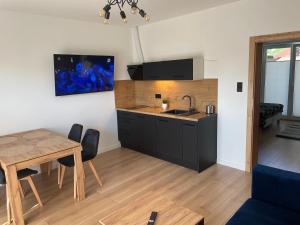a kitchen and dining room with a table and a sink at Urocze Apartamenty LOFT przy Molo in Chłopy