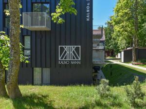 a black building with a sign on the side of it at Apartamentai “Viola” Juodkranteje in Juodkrantė