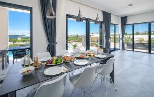 Un comedor con mesa y sillas y ventanas. en Villa Sea of Dreams, en Vodice