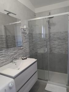 阿爾布斯的住宿－Monolocale Arbus R0478，浴室配有白色水槽和淋浴。