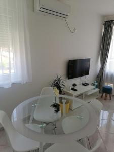 a white living room with a glass table and white chairs at Sweet Apartments in Split