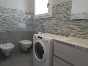 bagno con lavatrice e servizi igienici di Monolocale Arbus R0478 ad Arbus