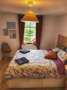 1 dormitorio con cama con edredón y ventana en Charming apartment Basel border - 3 bedrooms, en Hégenheim