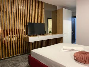 a bedroom with a bed and a flat screen tv at CLB Residence in Eforie Nord