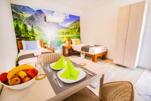 um quarto de hotel com uma mesa com fruta em Simo apartments airport Podgorica em Podgorica