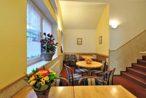 restauracja ze stołem, krzesłami i oknem w obiekcie PENSION ANNA w Szpindlerowym Młynie