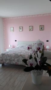 a bedroom with a bed and a vase with flowers at B&B A casa di Eleonora in Villafranca di Verona