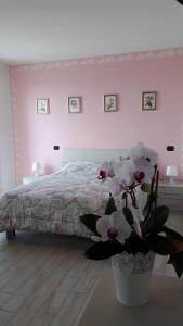 ヴィッラフランカ・ディ・ヴェローナにあるB&B A casa di Eleonoraのベッドルーム1室(ベッド1台付)、花瓶1本
