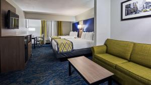une chambre d'hôtel avec un lit et un canapé dans l'établissement Best Western Knoxville Airport / Alcoa, TN, à Alcoa