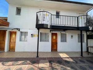a white building with a balcony on top of it at Residencial Astorga in Rancagua