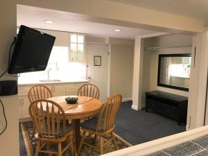 a kitchen and dining room with a table and a television at Cambie Lodge in Vancouver