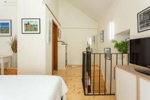 a room with a bed and a television and a staircase at Apartment Gorki in Split