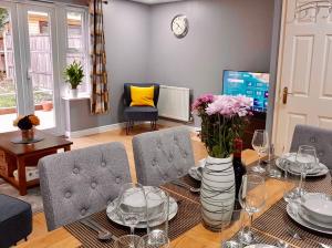 ein Wohnzimmer mit einem Esstisch mit Stühlen und einem Tisch in der Unterkunft Delight Marvel-Wexford Place, Maidstone in Maidstone