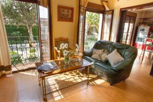 sala de estar con sofá de cuero y mesa de cristal en Casa Montelucía en Montecorto