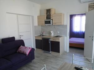 a living room with a couch and a kitchen at Apartmani Nevera in Krk +14 photos