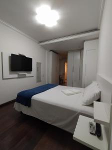 um quarto com uma cama grande e uma televisão de ecrã plano em Estadia das Gerais - Casa de hóspedes adorável com Jacuzzi em Ouro Preto