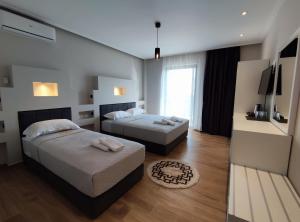Habitación de hotel con 2 camas y TV en Villa Primo Opus, en Ksamil