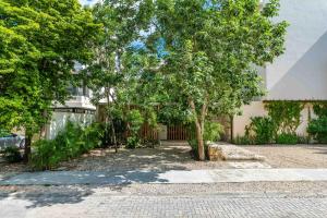 a house with a tree in the middle of a driveway at Sessile Tulum by The Spot Rentals in Tulum