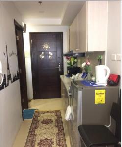 a small kitchen with a brown door and a counter at COZYMINIUM in Mega 2 at the HEART of Baguio City in Baguio