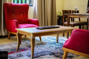 a living room with a red chair and a coffee table at Prime Nomads in Kisumu