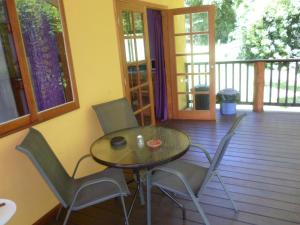 een tafel en stoelen op een terras met een veranda bij Teretre Cabins Nimbin in Nimbin