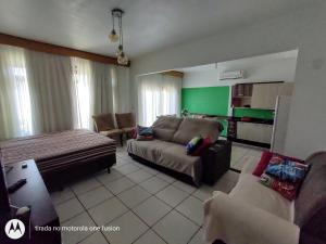 ein Wohnzimmer mit einem Sofa, einem Tisch und Stühlen in der Unterkunft Casa para hospedagem temporário in Joinville