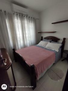 Schlafzimmer mit einem großen Bett mit einem Kopfteil aus Holz in der Unterkunft Casa para hospedagem temporário in Joinville